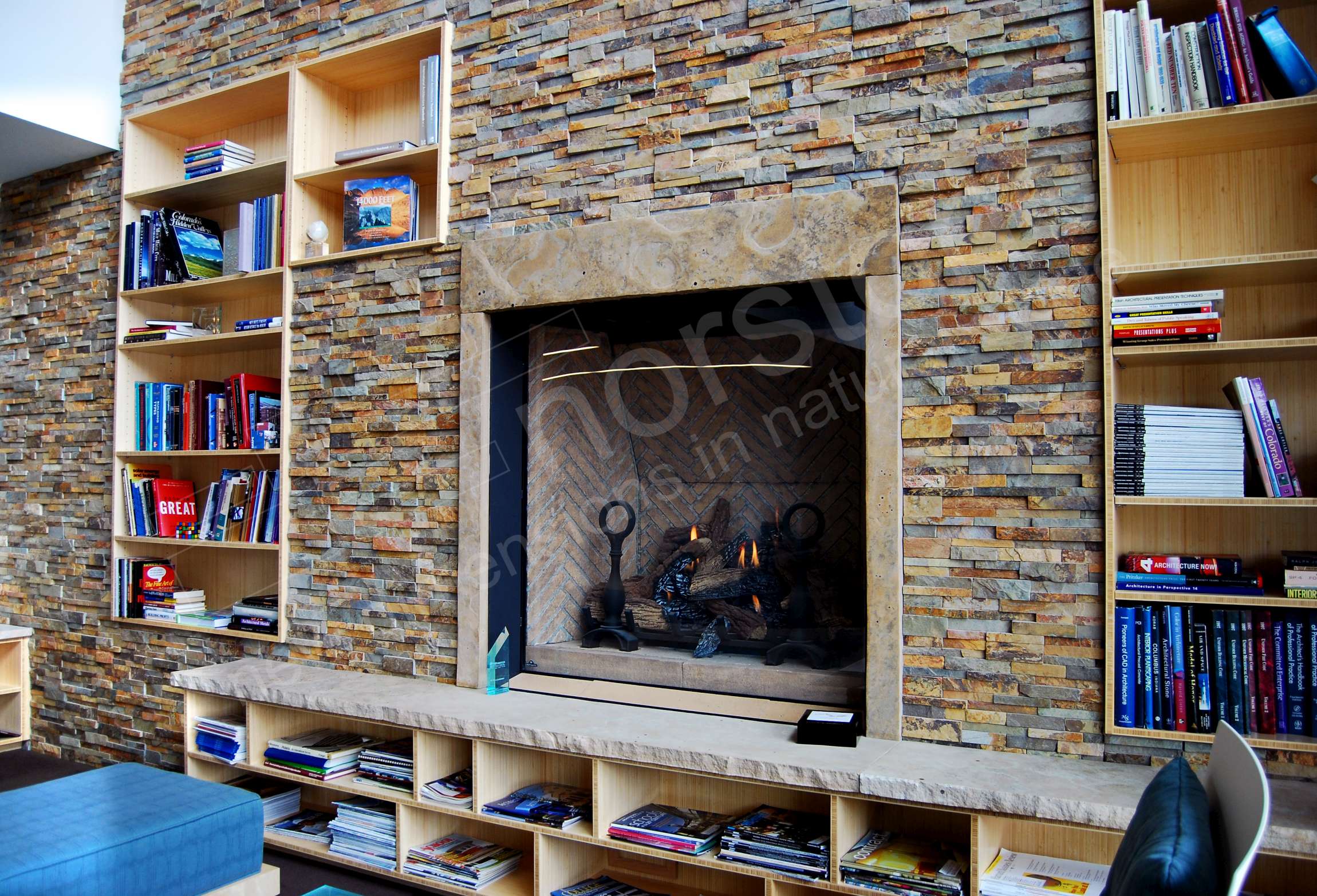 Natural Stone Veneer Fireplace with raised cut stone hearth with storage cubbies underneath it.